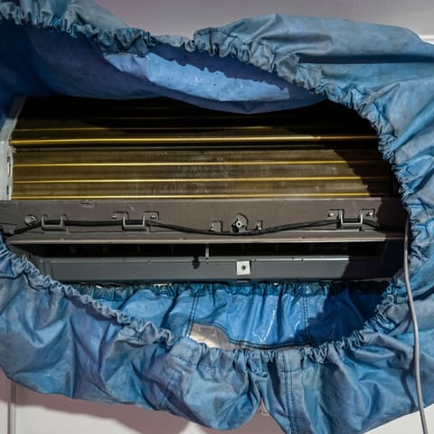 Lavado de aire acondicionado con funda de mantención durante un servicio de ServiClima